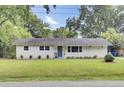 Charming single-story home featuring a landscaped lawn, a welcoming front door with a wreath, and light gray siding at 1515 Mulberry St, Charleston, SC 29407