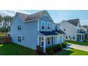 A bright blue two-story home with manicured lawns and colorful shrubbery at 201 Bigleaf Ct, Summerville, SC 29486