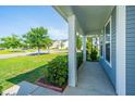 Inviting front porch with classic columns and view of the landscaped neighborhood at 201 Bigleaf Ct, Summerville, SC 29486