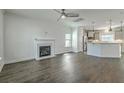 Open-concept living space with fireplace and hardwood floors leading into a modern kitchen at 211 Saxony Loop, Summerville, SC 29486