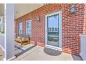Cozy front porch with brick accents, outdoor seating, and inviting entrance at 2931 Waterleaf Rd, Johns Island, SC 29455