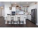 Modern kitchen featuring a large island, pendant lighting, stainless steel appliances, and white cabinetry at 324 Trailmore Ln, Summerville, SC 29486