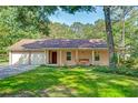 Inviting single-story home with a covered front porch and a swing, and an attached two car garage at 441 Compton Dr, Moncks Corner, SC 29461