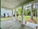 Relaxing front porch featuring stately columns, a concrete floor, and views of the lush front yard at 5702 Barbary Coast Rd, Hollywood, SC 29449
