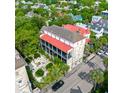 Aerial view of a grand building with a red roof surrounded by lush greenery and neighborhood houses at 81 Rutledge Ave, Charleston, SC 29401