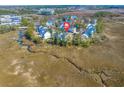 Aerial view of a home with a red marker on the roof surrounded by marshland and a winding creek at 840 Forrest Dr, Charleston, SC 29492