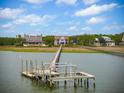 Picturesque waterfront view showcasing stunning homes and private boat dock, ideal for coastal living at 104 Beach St, Mount Pleasant, SC 29464