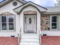 Inviting entryway with stone accents and a decorative glass door creating a warm welcome at 132 Tranquil Ln, Ladson, SC 29456