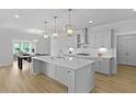 Open kitchen featuring an expansive island, modern pendant lights, and a view to the dining area at 133 Headwater Dr, Summerville, SC 29486