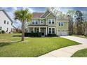 Charming two-story home features a manicured lawn, attached two-car garage, and a beautiful palm tree in the front yard at 136 Stagecoach Ln, Summerville, SC 29483