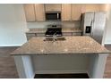 This kitchen island features a granite countertop, stainless steel sink, and ample storage space at 137 Haventree Ct, Summerville, SC 29486