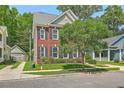 A cozy brick home with black shutters and a beautiful tree in the front yard at 1408 Bimini Dr, Charleston, SC 29414