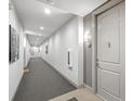 Long, neutrally decorated hallway with gray carpet, white walls, and doors leading to apartments at 145 Pier View St # 407, Charleston, SC 29492