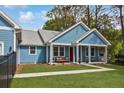 Charming home featuring a welcoming front porch with seating and a beautiful, well-manicured lawn at 1543 Scott Hill Rd, James Island, SC 29412