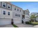 Beautiful exterior elevation of a townhouse featuring multi-car garages, neutral siding, and white trim at 185 Winding River Dr, Johns Island, SC 29455