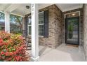 Inviting covered porch with brick exterior, black shutters and a comfortable seating area at 207 Brutus Ln, Summerville, SC 29485