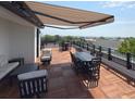 Spacious rooftop deck featuring wood tile flooring, comfortable seating, and a retractable awning at 21 George St # 102, Charleston, SC 29401