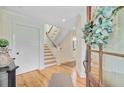 Bright foyer with hardwood floors, white wainscoting, and staircase leading to the second floor at 22 Beachwood East, Isle of Palms, SC 29451