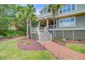 Beautiful front yard with brick pathway leading to the entrance of the house with mature landscaping at 22 Beachwood East, Isle of Palms, SC 29451