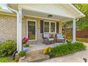 Inviting front porch with rocking chairs, flowers, and brick accents at 230 Azalea Ct, Moncks Corner, SC 29461