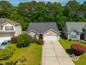 Aerial view of a well-maintained home with a long driveway and lush, mature landscaping at 261 Sweet Alyssum Dr, Ladson, SC 29456