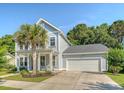 Stylish home featuring a well-kept lawn, palm tree, and convenient attached garage, perfect for modern living at 2652 Private Lefler Dr, Johns Island, SC 29455