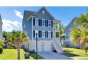 Two-story home with a driveway, garage, and a welcoming front porch under a blue sky with palm trees at 2820 Merriams Dr, Charleston, SC 29414