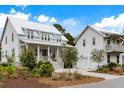 Inviting home showcasing its charming covered porch, well-manicured landscaping, and convenient two-car garage at 3023 Eventide Dr, Johns Island, SC 29455