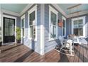 Inviting porch with a hanging swing, white wicker chair, and blue ceiling, perfect for relaxation at 308 Oak Park St, Summerville, SC 29486