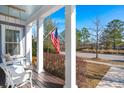 Relaxing porch with a hanging swing, overlooking a serene neighborhood street and lush greenery at 308 Oak Park St, Summerville, SC 29486