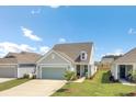 Inviting single-Gathering home with a two-car garage and a covered porch, surrounded by a green lawn at 350 Dahlia Row Dr, Summerville, SC 29486
