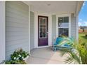 Charming front porch with a cozy bench, complemented by colorful flowers and lush greenery, and a window at 350 Dahlia Row Dr, Summerville, SC 29486