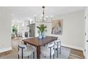 Bright dining room featuring a modern chandelier, wooden table, and a view of the adjacent kitchen at 397 Parkdale Dr, Charleston, SC 29414