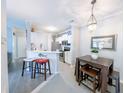 Cozy kitchen and dining area featuring white cabinets, stainless appliances, barstool seating, and modern lighting at 45 Sycamore Ave # 611, Charleston, SC 29407