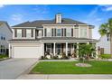 Beautiful two-story home with a covered front porch, green lawn, and a well-maintained landscape at 451 Spectrum Rd, Summerville, SC 29486