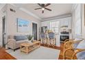 Cozy living room featuring a sofa, rattan chairs, hardwood floors and an eat-in kitchen at 5 1/2 Kracke St # A, Charleston, SC 29403