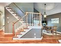 Bright staircase with white railings and wood trim, leading to dining area featuring an artful chandelier at 5359 Curtisston Ct, North Charleston, SC 29418