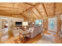 Comfortable living room with wood-paneled walls, a stone fireplace, hardwood floors, and cozy seating at 5519 Jefferies Hwy, Walterboro, SC 29488
