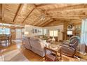 Cozy living room with hardwood floors, beamed ceilings, stone fireplace, and comfortable seating arrangement at 5519 Jefferies Hwy, Walterboro, SC 29488