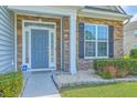 Inviting front entrance with stone accents, manicured shrubs, and a stylish front door at 575 Rosings Dr, Summerville, SC 29486