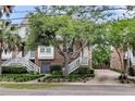 Inviting brick townhome featuring charming white stairs, established trees, and neat landscaping at 622 Windermere Blvd # D, Charleston, SC 29407