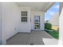 Covered patio showcasing white siding, a screened door, and a view of the home's exterior and landscaping at 109 Billowing Sails St, Summerville, SC 29486