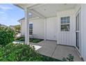 View of the covered patio with white columns, white siding, complemented by well-maintained landscaping at 109 Billowing Sails St, Summerville, SC 29486