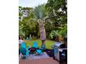 Outdoor entertaining area featuring a grill, a fire pit, and seating, all surrounded by lush greenery at 1145 Bellwood Rd, Charleston, SC 29412