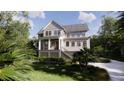Inviting two-story home with a covered porch and staircase, complemented by green landscaping at 117 Spartina Ct, Kiawah Island, SC 29455