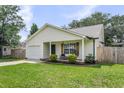 Single story home features a welcoming front porch with seating and well-manicured landscaping at 1302 Aubry Dr, Moncks Corner, SC 29461