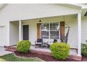 Charming front porch with seating and a hammock, complemented by tasteful landscaping at 1302 Aubry Dr, Moncks Corner, SC 29461