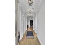 Elegant hallway with hardwood floors, stylish lighting fixtures, and neutral wall colors, leading to the living areas at 157 Pocket Bend Cir, Summerville, SC 29486