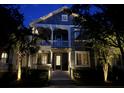 Beautiful two-story home with illuminated porch and landscaping at dusk, creating an inviting ambiance at 1588 Paradise Lake Dr, Mount Pleasant, SC 29464