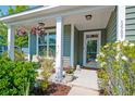 Inviting porch featuring rocking chair, potted plants, and decorative hanging baskets at 1589 Seabago Dr, Charleston, SC 29414